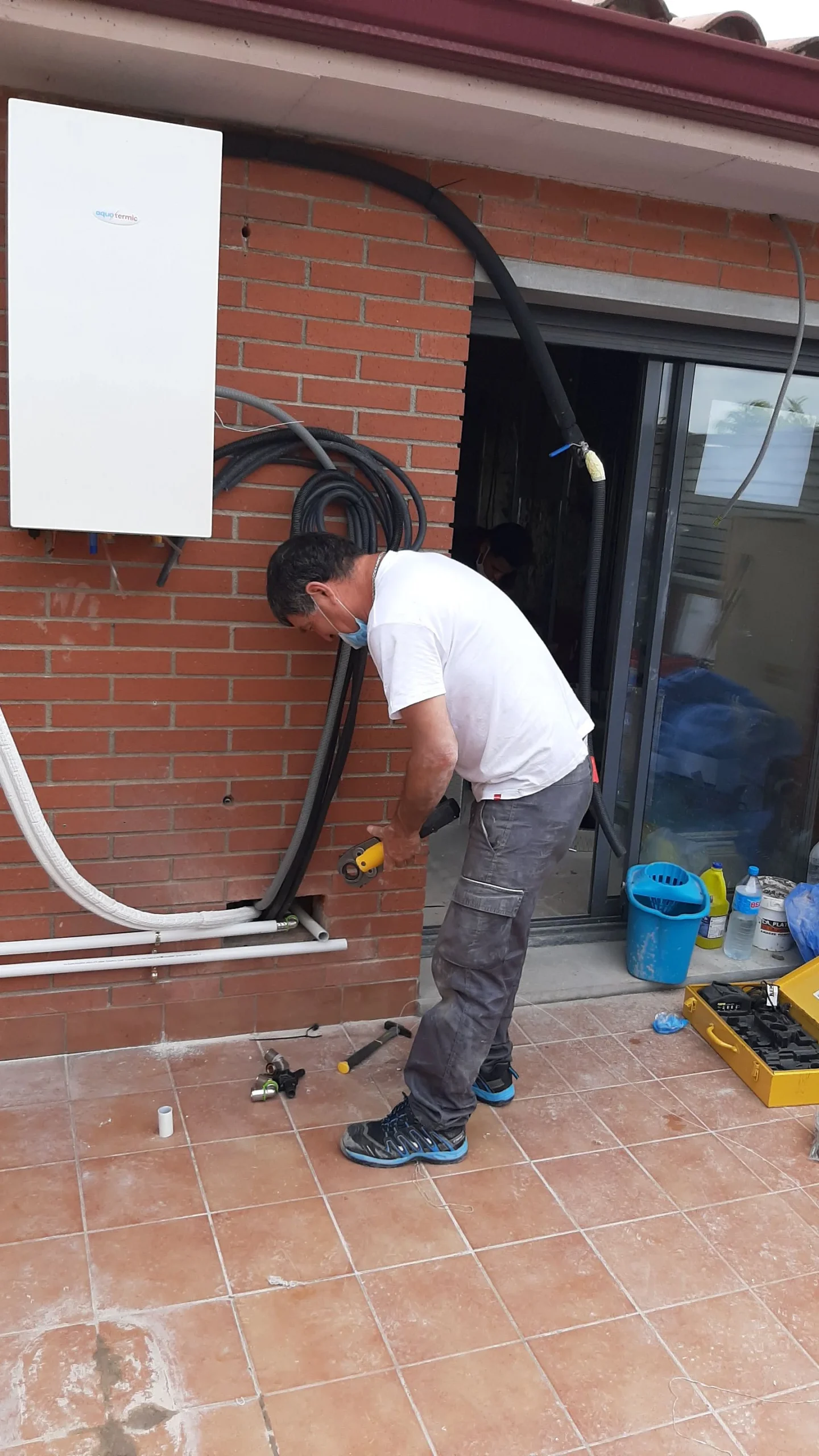 Instalador de CADI trabajando en una instalación de aerotermia en una vivienda