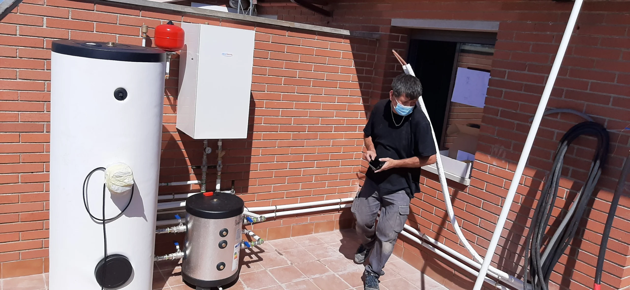 Técnico de CADI instalando un equipo de aerotermia que sustituye a una caldera de gas